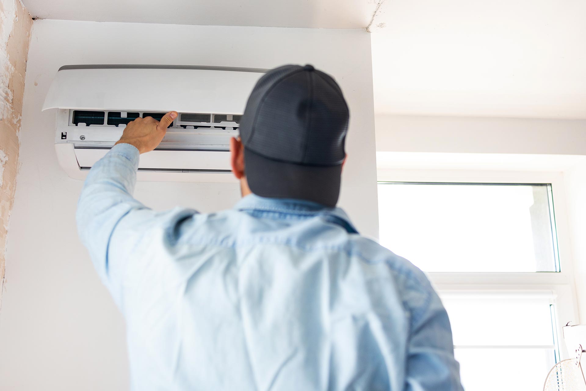 young-male-technician-repairing-air-conditioner-in-2024-05-06-19-49-40-utc